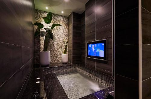 a bathroom with a tub with a tv in it at Motel Lin in Taichung