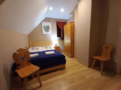 1 dormitorio con 1 cama y 1 silla en Domek na Polnej, en Czorsztyn