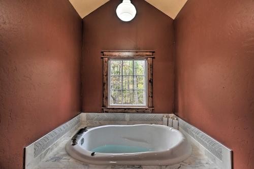 a bath tub in a room with a window at Tudor-Style Cottage with 2 Decks and Hot Tub! in Stephens Gap