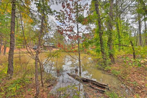 a small river in the middle of a forest at Tudor-Style Broken Bow Cottage with Hot Tub and Decks! in Stephens Gap