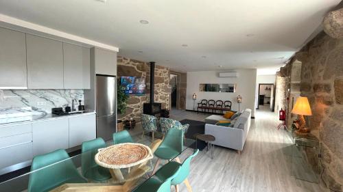 a kitchen and living room with a table and chairs at Casa da Torre in Lapela