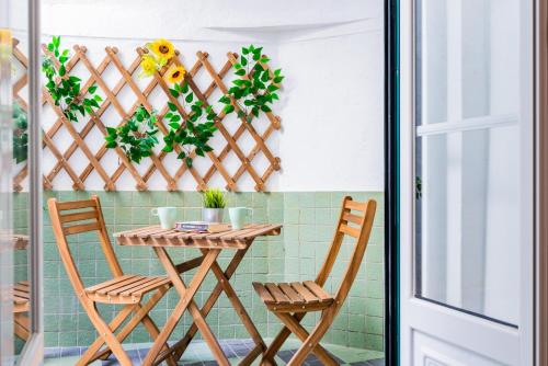 einen Tisch und Stühle auf einem Balkon mit Pflanzen in der Unterkunft Olarias Terrace Lisbon in Lissabon