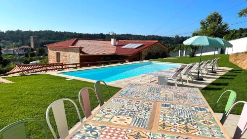 a table and chairs next to a swimming pool at Casa da Torre in Lapela