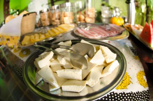 a table with a plate of cheese and other foods at Pousada Solar do Algarve in Paraty