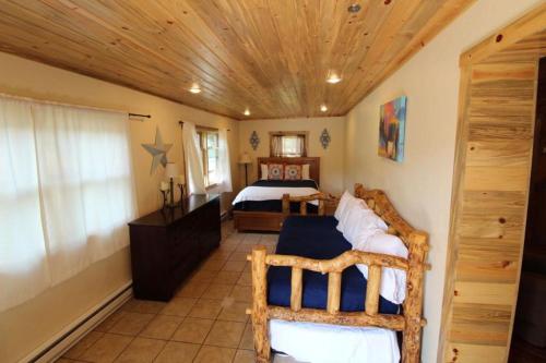 a bedroom with two bunk beds and a wooden ceiling at Wapiti Lodge in Wapiti