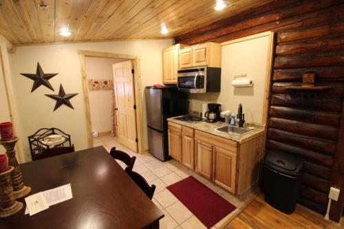 a kitchen with a table and a refrigerator and a counter at Wapiti Lodge in Wapiti