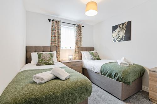 a bedroom with two beds and a window at Alma Accommodation - TV in Every Bedroom! in Swansea