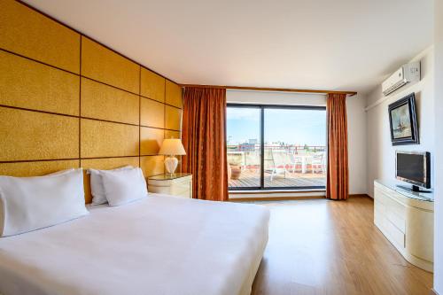 布魯塞爾的住宿－蒙哥馬利B公寓式酒店，卧室设有一张白色大床和大窗户