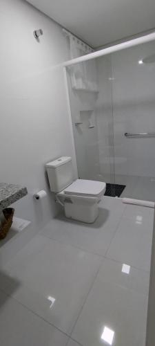 Habitación con baño blanco con aseo. en Apartamento Climatizado Familiar NOVO Ed Lírio do Vale Próx ao Termas de Piratuba SC, en Piratuba