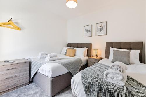 two beds sitting next to each other in a bedroom at Hilltop House - TV in Every Bedroom! in Merthyr Tydfil