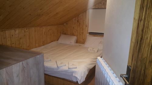 a small bed in a room with a wooden ceiling at Villetta di Faraya in Fārayyā