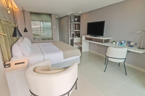 a bedroom with a bed and a desk and a tv at Sonesta Hotel Cartagena in Cartagena de Indias