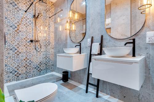 La salle de bains est pourvue de 2 lavabos et de toilettes. dans l'établissement Modern Italia Apart - 100m Main Square - parking and lift, à Wrocław