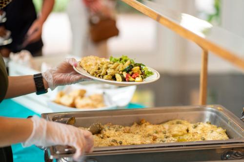 a person holding a plate of food on a table at Sweetwater Branch Inn in Gainesville