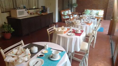 a dining room with tables and chairs with dishes on them at Villas Del Sol Bed & Breakfast in Lima