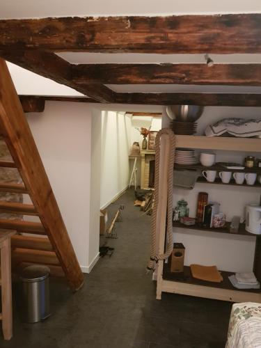 an attic room with wooden ceilings and a room with shelves at Le Petit Studio in Cosswiller