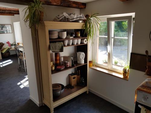 una habitación con una estantería con platos y una ventana en Le Petit Studio, en Cosswiller