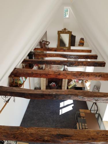 vistas a un loft con escaleras de madera en Le Petit Studio, en Cosswiller