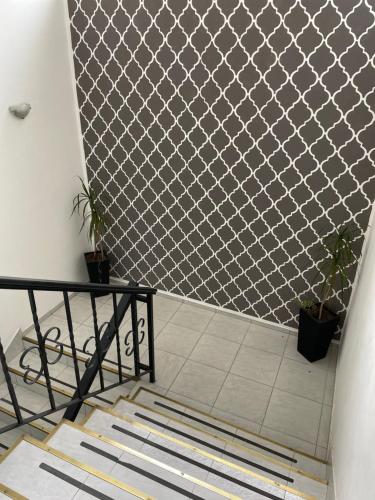 a staircase with a white tile floor and a fence at Piazza Suites 2 in Mendoza