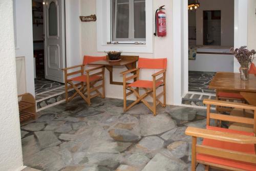 a patio with a table and chairs on a stone floor at Papafragas Studios in Pachaina