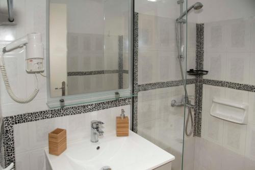 a white bathroom with a sink and a shower at Papafragas Studios in Pachaina