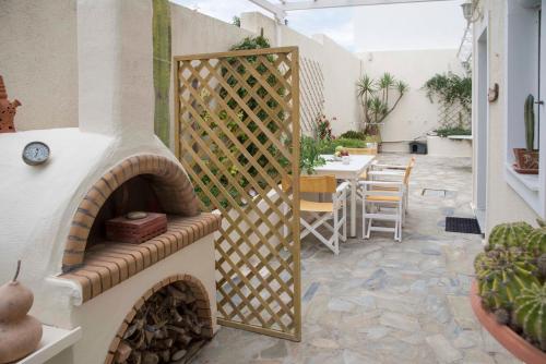 a patio with a wooden gate with a table and chairs at Papafragas Studios in Pachaina