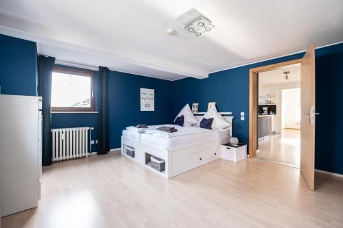 sypialnia z białym łóżkiem w niebieskiej ścianie w obiekcie Ferienwohnung mit Kuschelflair w Essen