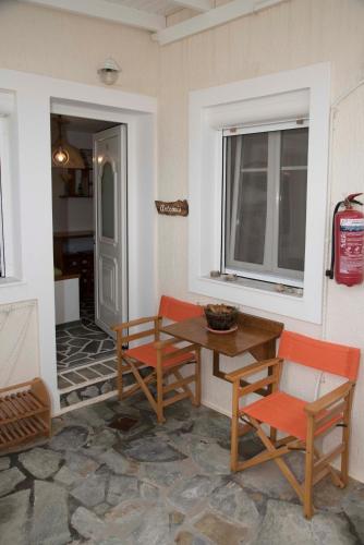 a patio with a table and chairs and a window at Papafragas Studios in Pachaina