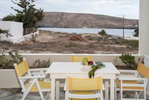 a white table and chairs with a view of the water at Papafragas Studios in Pachaina