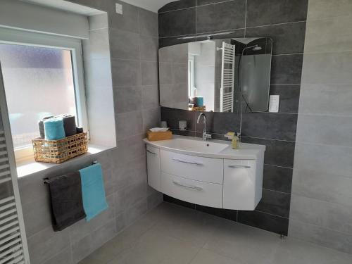 La salle de bains est pourvue d'un lavabo, d'un miroir et d'une fenêtre. dans l'établissement Gite de la Creuse (Vosges), à Fays