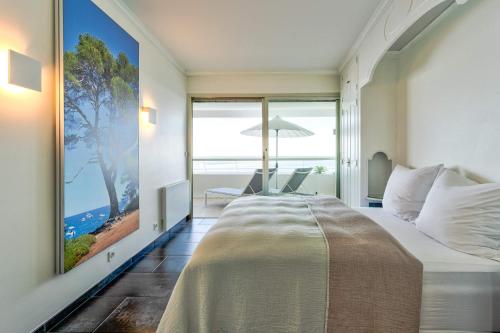 une chambre avec un grand lit avec vue sur l'océan dans l'établissement Annabelle, à Villeneuve-Loubet