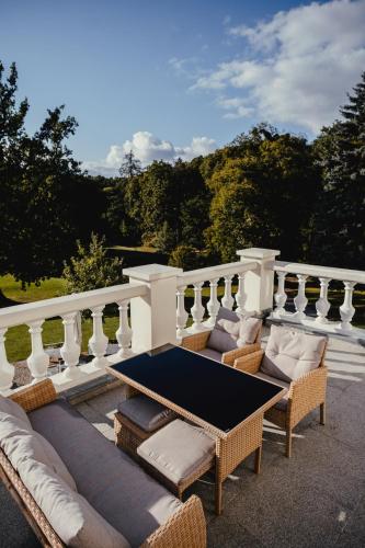 a patio with couches and a table on a balcony at Hanza Pałac Wellness & SPA in Warlubie