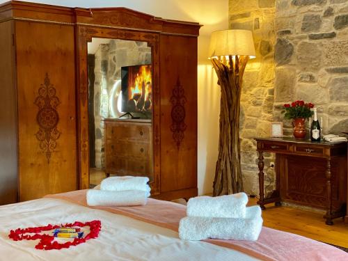 a bedroom with a bed with two towels on it at The Houses of History - anno 1830 in Tihany