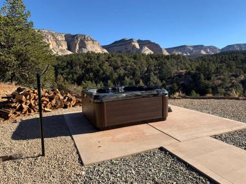 a hot tub sitting on the ground with mountains in the background at Skyfall Cabin. Stunning views, Hot Tub, minutes from Zion in Orderville