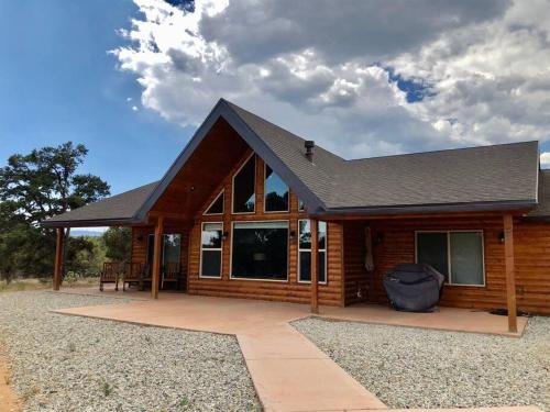 a log cabin with a patio in front of it at Skyfall Cabin. Stunning views, Hot Tub, minutes from Zion in Orderville