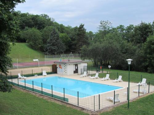 een groot zwembad met stoelen en een volleybalveld bij VVF Montpeyroux Auvergne in Parent