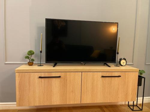 a flat screen tv sitting on top of a wooden cabinet at BW Luxury Apartment Bijeljina in Bijeljina