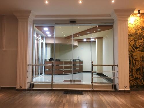a lobby with a glass wall and a staircase at Hotel Lovusiyah in Jaffna