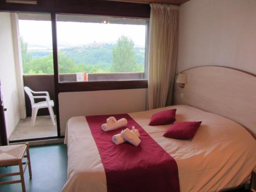 een slaapkamer met een bed met twee handdoeken erop bij VVF Montpeyroux Auvergne in Parent