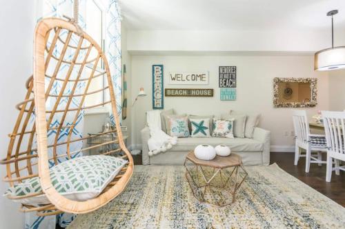 a living room with a rattan chair and a couch at Tropical Coastal Resort Boynton Beach in Boynton Beach