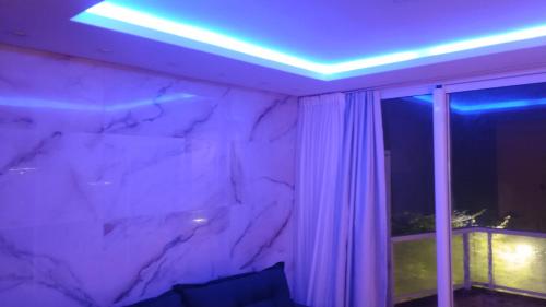 a room with a marble wall and a purple light at Apartamento de Cobertura frente para o mar Itapema in Itapema