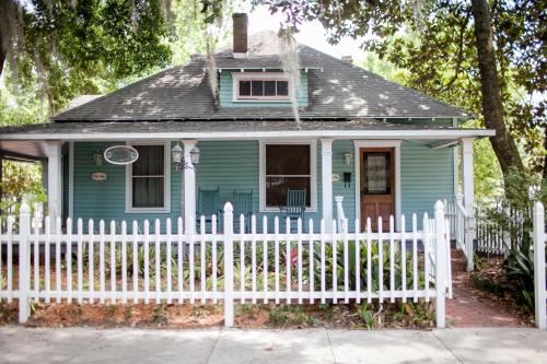 a blue house with a white picket fence at Sweetwater Branch Inn in Gainesville