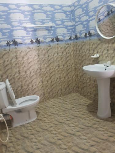 a bathroom with a toilet and a sink and a mirror at Sea Port Hiriketiya in Hiriketiya