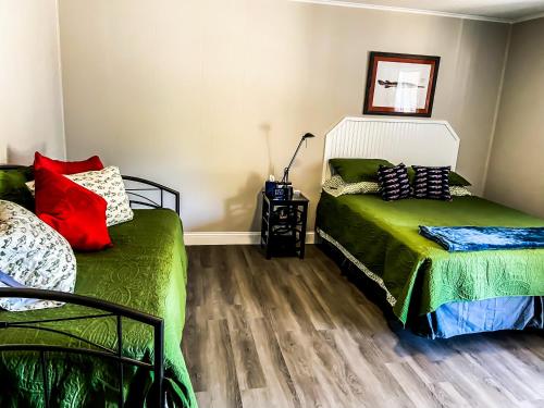 a bedroom with two beds and a wooden floor at Reel Inn and Lodge in Quitman