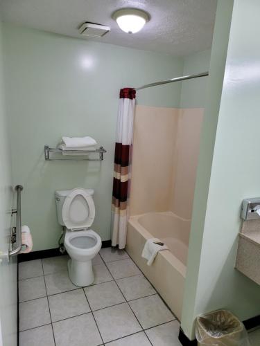 a bathroom with a toilet and a bath tub at Relax Inn in Marshall