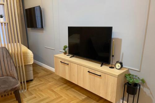 a flat screen tv sitting on top of a wooden cabinet at BW Luxury Apartment Bijeljina in Bijeljina