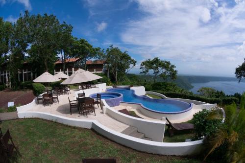 ein Resort mit einem Pool, Tischen und Stühlen in der Unterkunft Pacaya Lodge and Spa in La Laguna