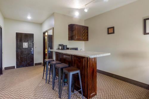a kitchen with a counter and stools in a room at Comfort Inn Hobart-Merrillville I-65 in Merrillville