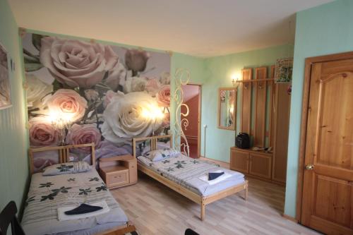 two beds in a room with a mural of flowers at Slavyanskii Dvor in Gatchina