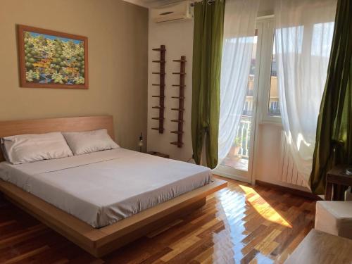 a bedroom with a bed and a large window at Ciampino Airport Apartment in Ciampino